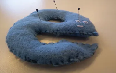 An Internet Explorer logo pin cushion with pins sticking out