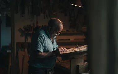 a man in a workshop carving wood