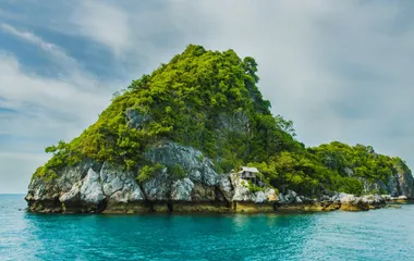 A very small island in a gulf with a small dwelling on the rocks